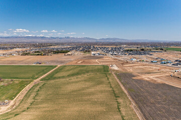 Farm fields with new construction and mountains of Boise