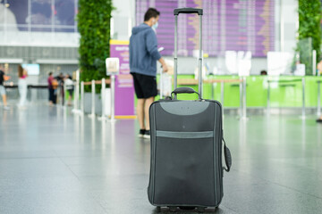 suitcase standing on the floor in modern airport terminal. Copy space