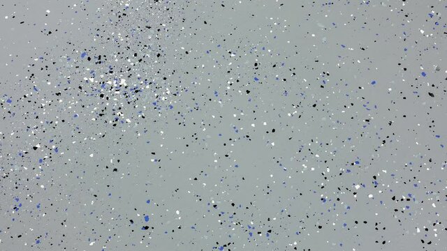 Zooming in on a freshly painted garage floor with a gray epoxy finish sprinkled with blue, black and white plastic chips.