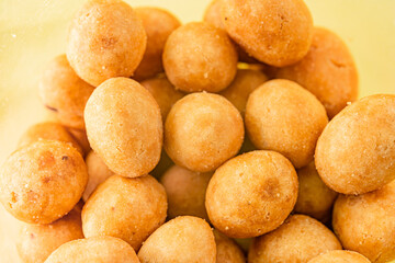 Peanuts in glaze on yellow background