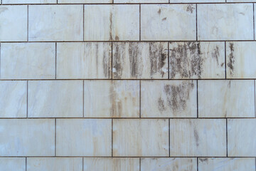 Selective focus shot of a dirty tiled wall outdoors