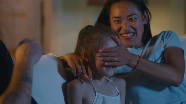 Parents watching movie with daughter at night