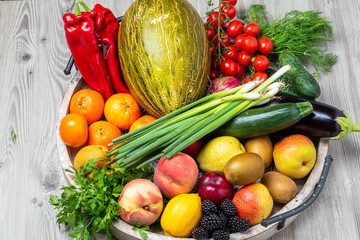 Fruits and vegetables in a wooden tray on grey wooden table background