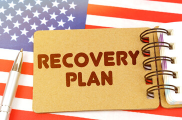 Fototapeta na wymiar On the US flag lies a notebook with the inscription - RECOVERY PLAN