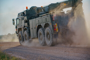 British army MAN SX45 32.430 8x8 recovery vehicle throwing up clouds of dust, in action on a military battle exercise, Wilts UK