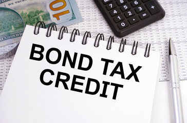 On the table there is money, a calculator and a notebook with the inscription - Bond Tax Credit