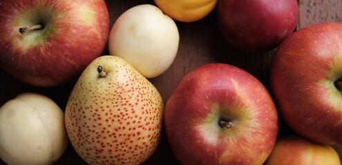 Juicy fruits on a old wooden table. Apples, pears, plums, apricots, close up