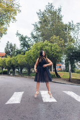 Latin teen girl, ballerina in black costume and ballet shoes doing a figure on ap