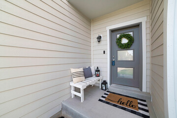 Small front porch with white bench and gray front door