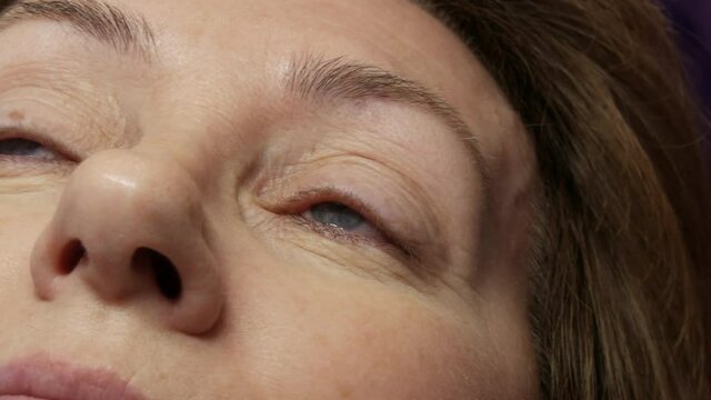 Adult woman face on modern eyelash lamination procedure in a professional beauty salon before the eyelash curling procedure.