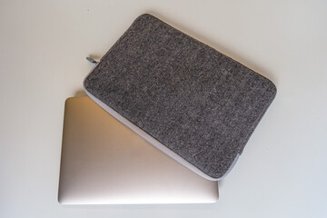 A laptop inserted gray computer case with open zipper. White background. Technology.
