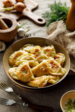 Fried dumplings stuffed with curd cheese and potatoes in a ceramic bowl. A traditional dish of Polish cuisine.