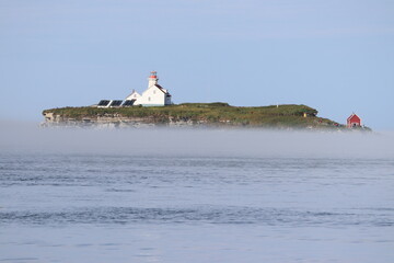 L'île aux perroquets dans le nord du Québec avec une léger brouillard matinal sous un ciel bleu