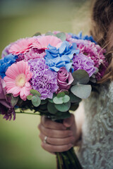 wedding bridal bouquet with flowers in blue, pink and purple