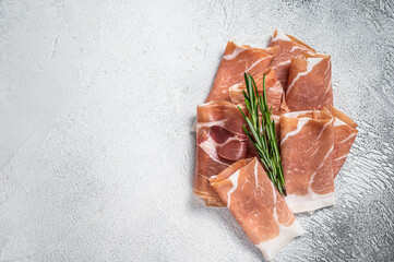Italian prosciutto crudo parma ham on a table. White background. Top View. Copy space