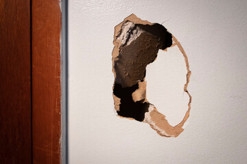 Large hole in damaged drywall, in need of repair - obrazy, fototapety, plakaty