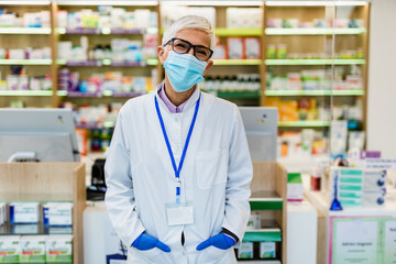Senior female pharmacist with protective mask on her face working at pharmacy. Medical healthcare, Coronavirus, Covid-19 concept.