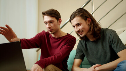 Two friends are speaking with someone on the Internet