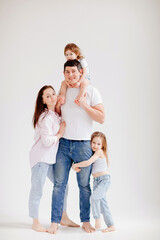 Fototapeta premium beautiful happy family in a white photo studio. parent-child relationship