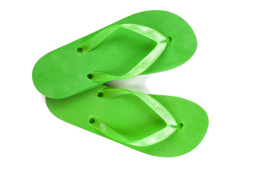 green rubber beach flip flops on a white background, isolate, view from above