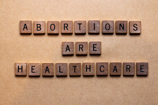 Wooden letters spelling out abortions are healthcare. Relevant to the Texas SB8 law that bans virtually all abortions after six weeks based on the heartbeat principle. Women's rights, reproduction.