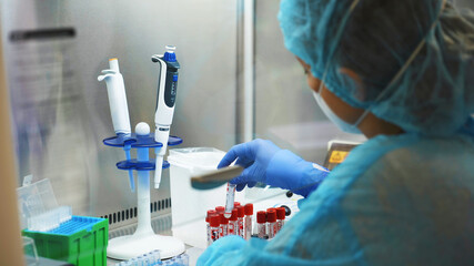 medical worker conducts a study of PCR tests for coronavirus in a laboratory.. back view  Close-up