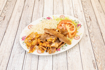 Mixed kebab plate with rice and lettuce with tomato. Grilled chicken and lamb