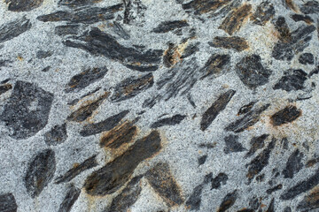 The texture of the rock. White stone with black spots. Natural background surface of cobblestones.
