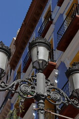 Fototapeta na wymiar Black wrought iron street lamp on a street in Zaragoza, Aragon, Spain. Vertical image.