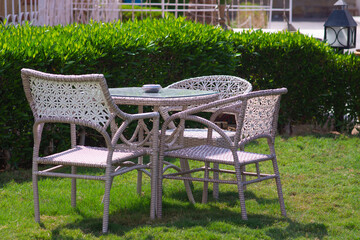 a table and chairs on a green meadow. without people. street cafe in Egypt at the hotel.