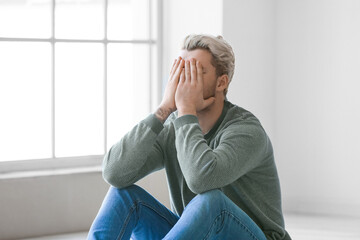 Depressed young man in empty room