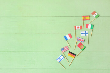 Flags of different countries on color wooden background