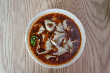 A bowl of delicious spicy Chinese dumplings