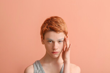 Teenage boy with dyed eyebrows on color background