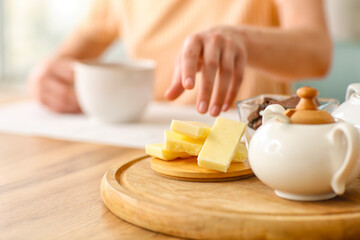 Board with tasty chocolate and teapot on table, closeup