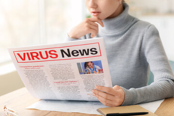 Young woman reading newspaper at home, closeup