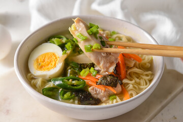 Tasty Chinese soup with chicken in bowl on light background, closeup