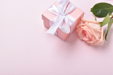 One pink rose and a gift box.