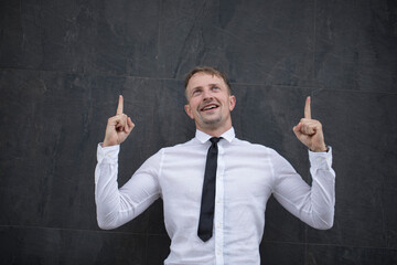 Portrait of excited satisfied cunning cheerful confident curious positive delightful handsome creative active laughing freelancer demonstrating thumbs-up pointing up 