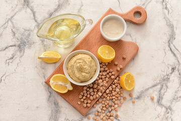 Composition with tasty hummus and ingredients on light background