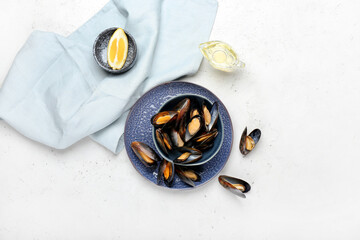 Bowl with tasty mussels on light background