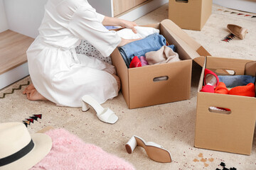 Young woman arranging clothes at wardrobe
