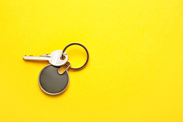 Key with stylish keychain on color background