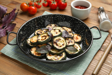 Frying pan with tasty grilled zucchini on wooden background