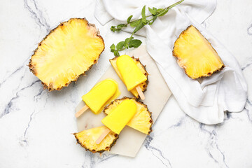 Board with tasty pineapple popsicles on light background