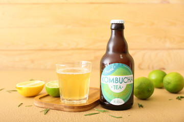 Bottle and glass of tasty kombucha tea on table