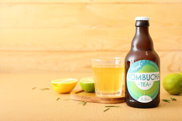 Bottle and glass of tasty kombucha tea on table