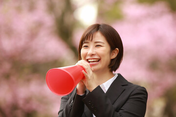 メガホンを持ち声援を送る女性社員