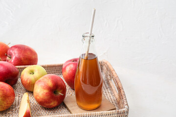 Bottle of apple juice and fresh fruits on light background, closeup
