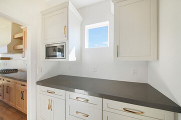 Kitchen counter with gray counter and white drawers with gold handles